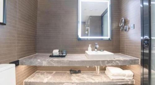 a bathroom with a sink and a mirror at Xana Hotelle Zhuhai Gongbei Port in Zhuhai