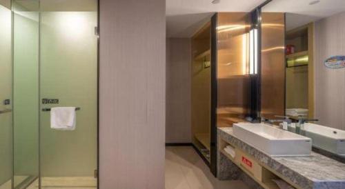 a bathroom with a sink and a mirror at Echarm Hotel Taizhou International Convention and Exhibition Center 