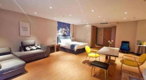a hotel room with a bed and a couch at Magnotel Shenyang Consulate Qingnian Street in Shenyang