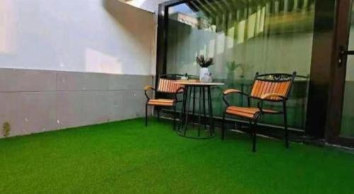 a patio with green grass and chairs and a table at Magnotel Shenyang Consulate Qingnian Street in Shenyang