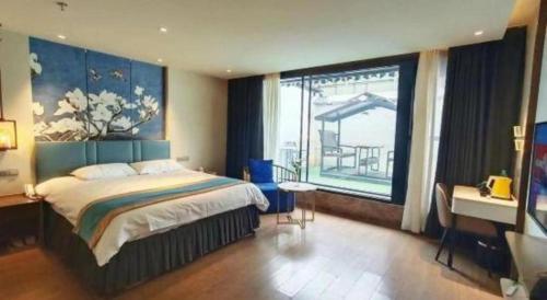 a bedroom with a bed and a desk and a window at Magnotel Shenyang Consulate Qingnian Street in Shenyang