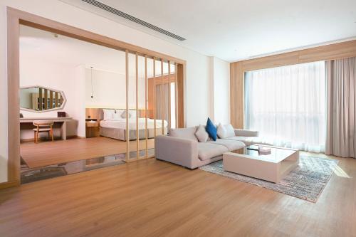a living room with a couch and a bedroom at Nordic Palace and spa in Manama