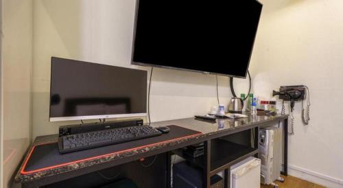 a desk with a computer monitor and a keyboard at Yongin Valentine in Yongin