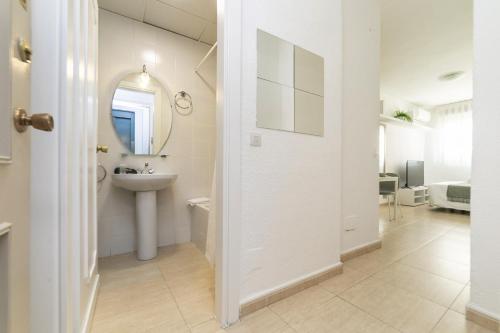a white bathroom with a sink and a mirror at Classy VII - Ferga Suites in Madrid