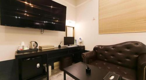 a living room with a desk and a leather chair at Hotel Seowa in Gimhae