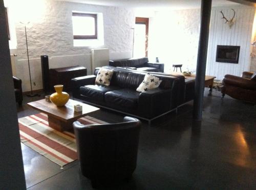 a living room with a couch and a table at Le Menil in Manhay