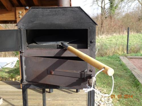 a black smoker with a baseball bat in it at Le Chalet au vieux vignoble avec espace Sauna et Jacuzzi in Bouxwiller
