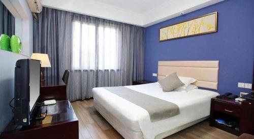 a bedroom with a bed and a tv and blue walls at Hangzhou Bokai Westlake Hotel in Hangzhou