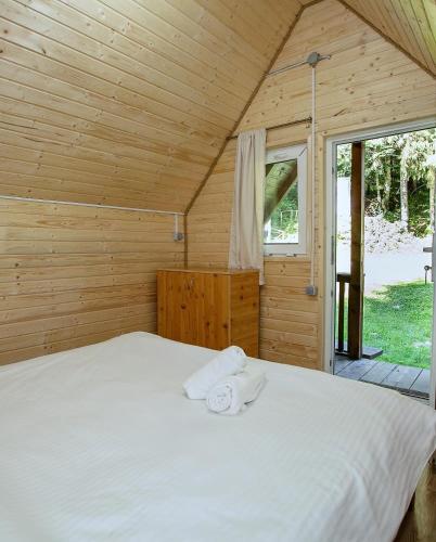 a bedroom with a bed in a wooden cabin at Transfagarasan Moto&Cabin Camp in Arefu