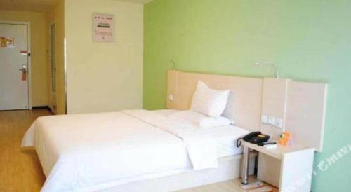 a large white bed in a room with a telephone at 7 Days Inn Guangzhou Zoo Huanghuagang Metro Station in Guangzhou