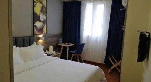 a hotel room with a bed and a table and a window at 7 Days Inn Changzhou Yancheng Technology Metro Station in Changzhou