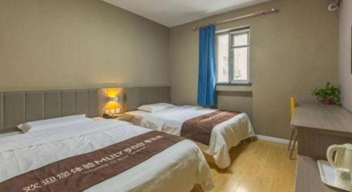 a hotel room with two beds and a window at 7 Days Inn Qingdao Si Liu South Road in Qingdao