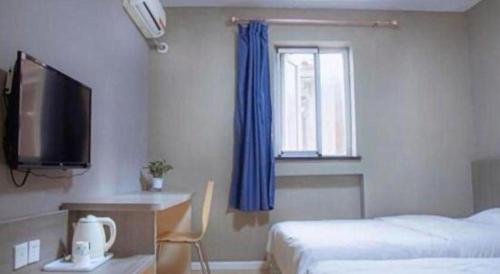 a bedroom with a bed and a tv and a window at 7 Days Inn Qingdao Si Liu South Road in Qingdao