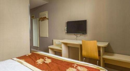 a room with a desk and a tv on the wall at 7 Days Inn Qingdao Si Liu South Road in Qingdao