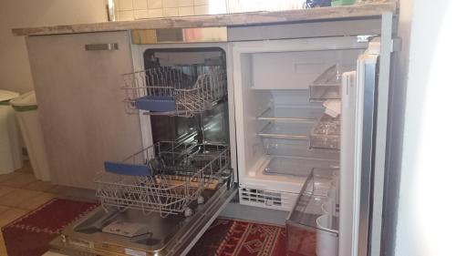 an empty refrigerator with its door open with its shelves at Haus Sonja in Lermoos