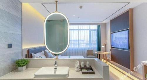 un baño con lavabo y espejo en GreenTree Inn Shandong Jinan Suncun New District Express Hotel, en Jinan