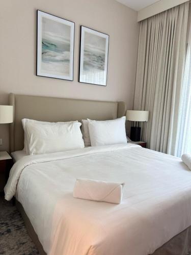 a large white bed in a hotel room at Address Beach Resort Fujairah Apartment by Blue World - 3 in Fujairah