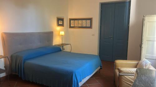 a bedroom with a blue bed and a chair at Villa del glicine in Muro Leccese
