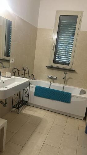 a bathroom with a tub and a sink and a window at Villa del glicine in Muro Leccese