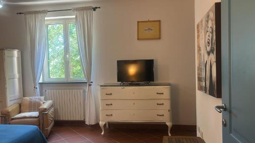 a bedroom with a dresser with a tv on top of it at Villa del glicine in Muro Leccese