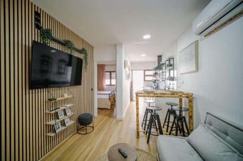 a living room with a couch and a tv on a wall at Apartamento JADA in Albufeira
