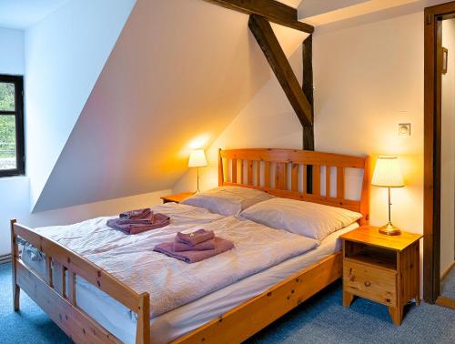 a bedroom with a wooden bed with two towels on it at Penzion My Lady II in Heřmanice