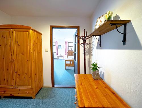 a room with a wooden table and a wooden cabinet at Penzion My Lady II in Heřmanice