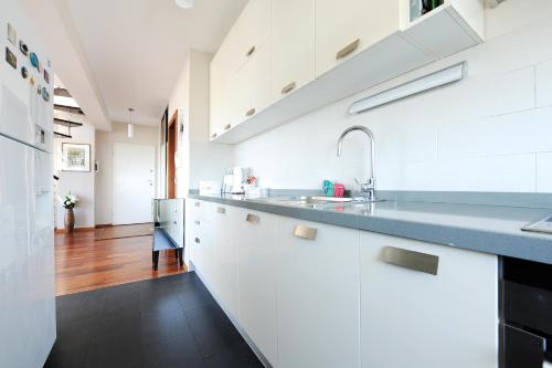 a kitchen with white cabinets and a sink at Sunset Penthouse Apartment with Jacuzzi and Seaview in Zadar