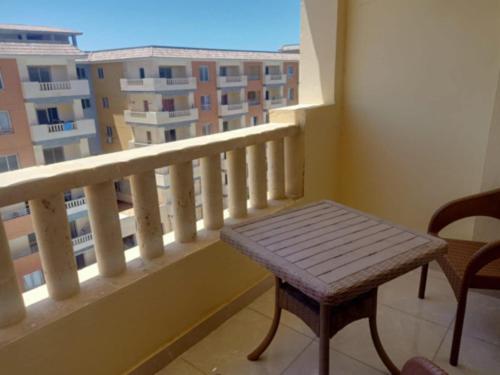 a bench on a balcony with a view of a building at شاليه بالساحل الشمالى قرية نيو كوست الكيلو 77 قبلى الطريق بشاطىء خاص in El Alamein