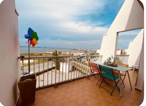 un balcon avec une table et des chaises sur un balcon dans l'établissement Appartement 1ère ligne Vue mer, accès direct plage, à Palavas-les-Flots