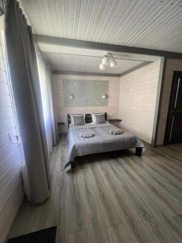a bedroom with a bed and a wooden floor at Фенікс in Yaremche