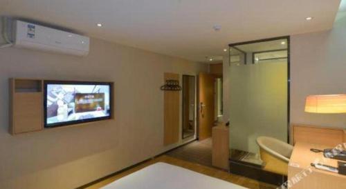 a living room with a television on the wall at IU Hotel Anshun Zhenning Huangguoshu Scenic Area Toursit Center in Anshun