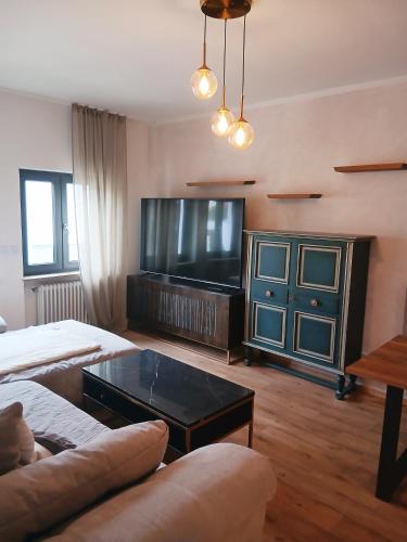 a living room with a couch and a large television at Hotel Via Vita in Treuchtlingen