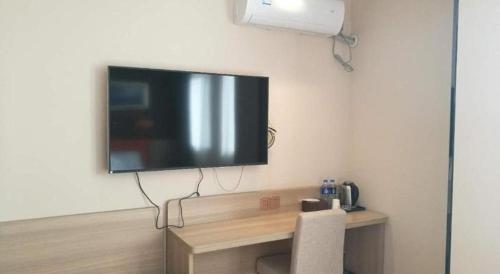 a flat screen tv hanging on a wall at 7 Days Premium Yancheng Dafeng Zhongjiao Meilu City in Yancheng