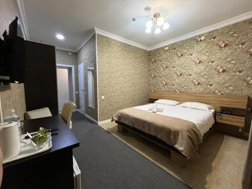 a bedroom with a bed and a bathroom with a sink at Hotel "CONTINENT" halal in Karagandy