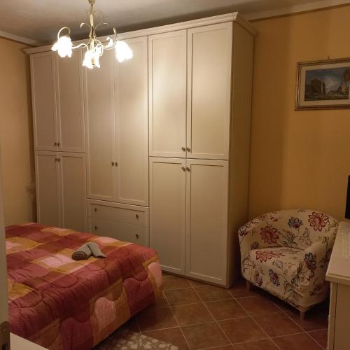a bedroom with a bed and a chair at la Casa del Glicine in Mortaiolo