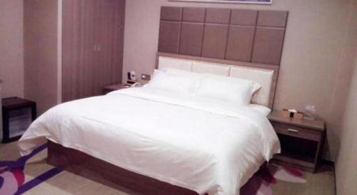 a bedroom with a large white bed with a headboard at Lavande Hotels Dalian Software Park University of Technology in Dalian