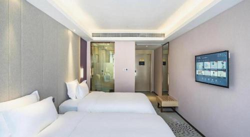 a hotel room with two beds and a flat screen tv at Lavande Hotel Jiande Xin'an River in Thousand Island Lake