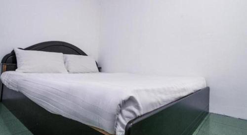 a bed with white sheets and pillows in a room at OYO 89706 To-day Hotel in Sibu