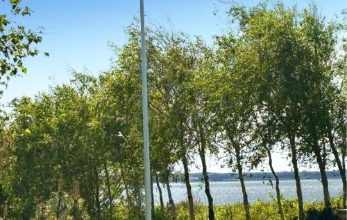 a pole in front of trees and a body of water at 3 Bedroom Cozy Home In Fur in Fur