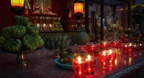 a table with candles and fruits on a table with lights at ADALY Hotel in Xuan An