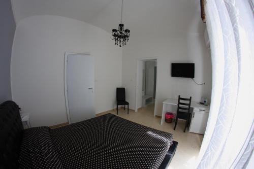 a living room with a couch and a television at Gualtiero Camere & Suite in Caltagirone