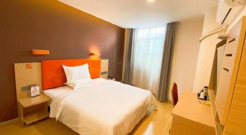 a bedroom with a white bed and a window at 7 Days Premium Hotel Ji'an Taihe Gongnongbing Avenue in Ji'an