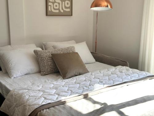 a bed with white sheets and pillows in a room at The Bayview apartment in Donji Morinj