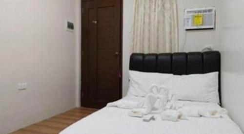 a bedroom with a white bed with a black headboard at Pilot Hotel in Alaminos