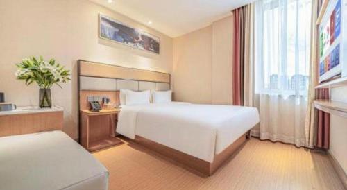 a hotel room with two beds and a window at GreenTree Inn Geermu Walking Street Business Hotel in Golmud