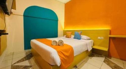 a bedroom with a bed with orange and blue at OYO Life 92127 Skyland Pasteur in Bandung