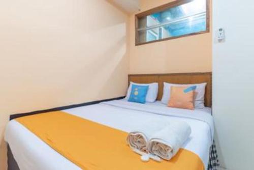 a bedroom with a large bed with orange and blue pillows at OYO Life 92127 Skyland Pasteur in Bandung