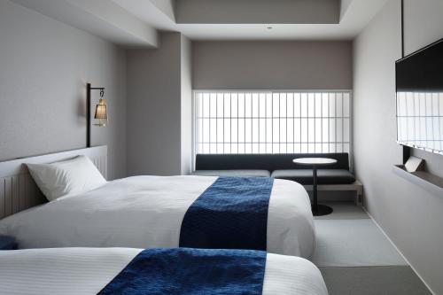 a hotel room with a bed and a window at HOTEL TORIFITO KANAZAWA in Kanazawa