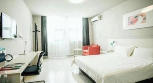 a bedroom with a large white bed and a desk at Jinjiang Inn Yancheng Funing Harbin Road in Yancheng